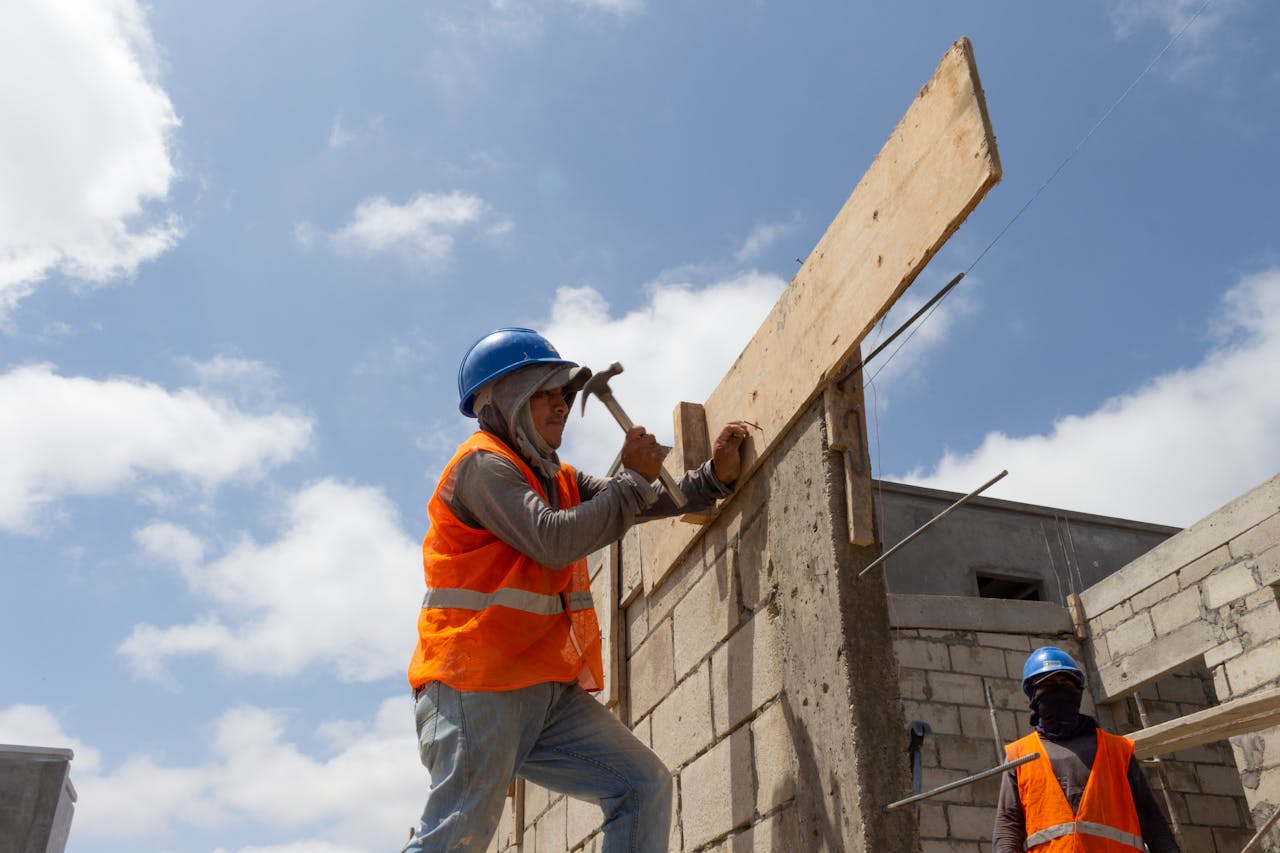 Construction workers building a structure in Ballenita, Ecuador under a clear sky.